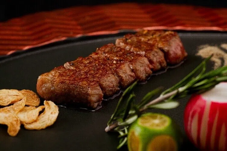 雪花牛排入口是满满牛脂香气与铁板焦香。（餐馆提供）