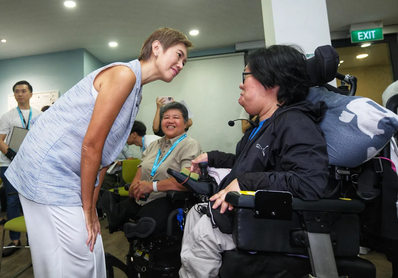 数码发展及新闻部长杨莉明（左）在包容性设计周活动现场，与脊髓性肌萎缩症患者游莉平互动交流，了解她在使用数码服务时的体验。（曾坤顺摄）