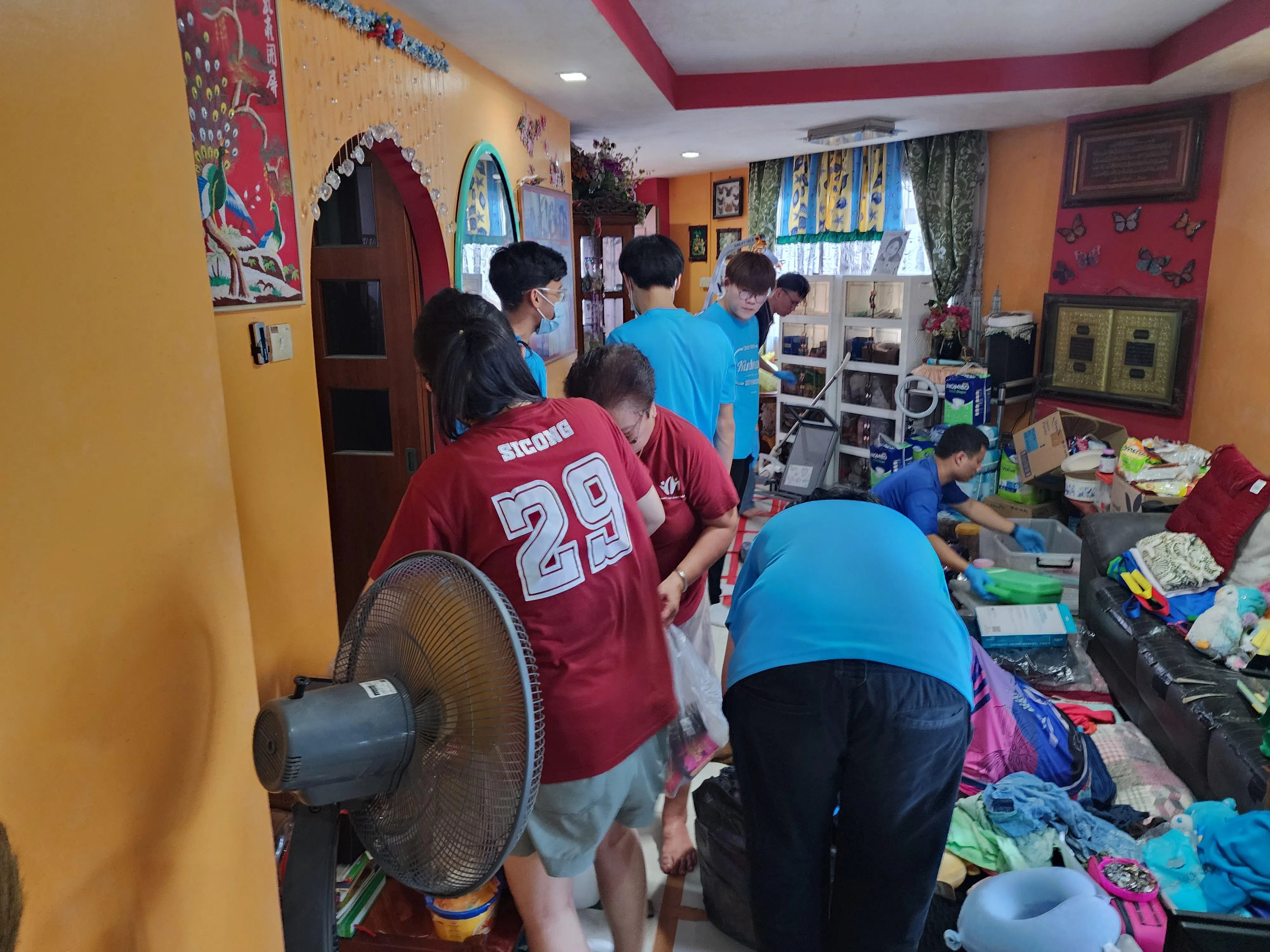 一群义工去年12月21日在文礼一组屋单位进行打扫。根据现有机制，受邻居囤积杂物影响的居民，可向邻里纠纷审裁庭求助。若囤积情况已造成不合理干扰，审裁庭可下令囤积者清理住所。（国家发展部提供）