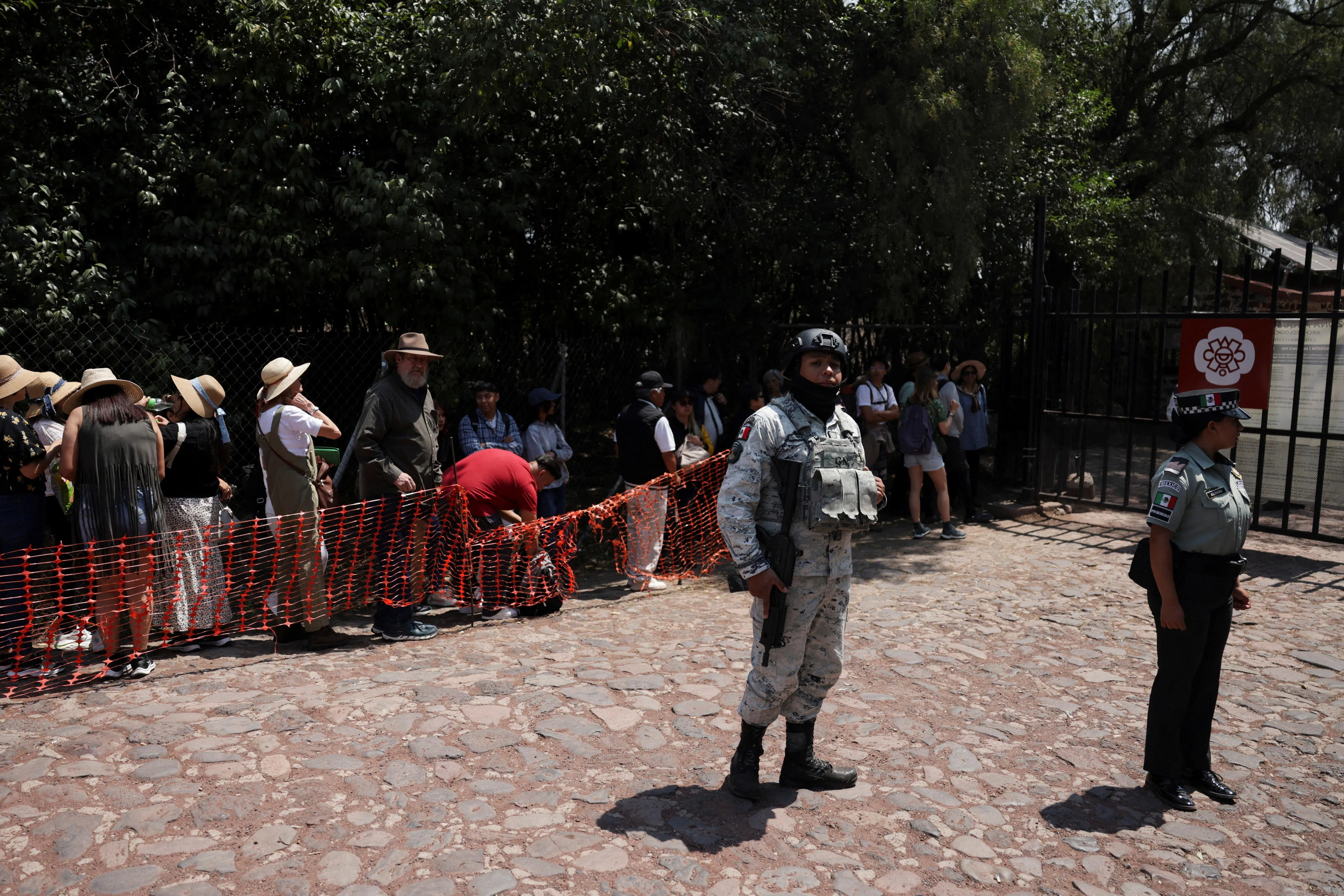 特奥蒂瓦坎金字塔景区在严密的安保措施下重新开放，游客在烈日下排队等着进入景区。（路透社）