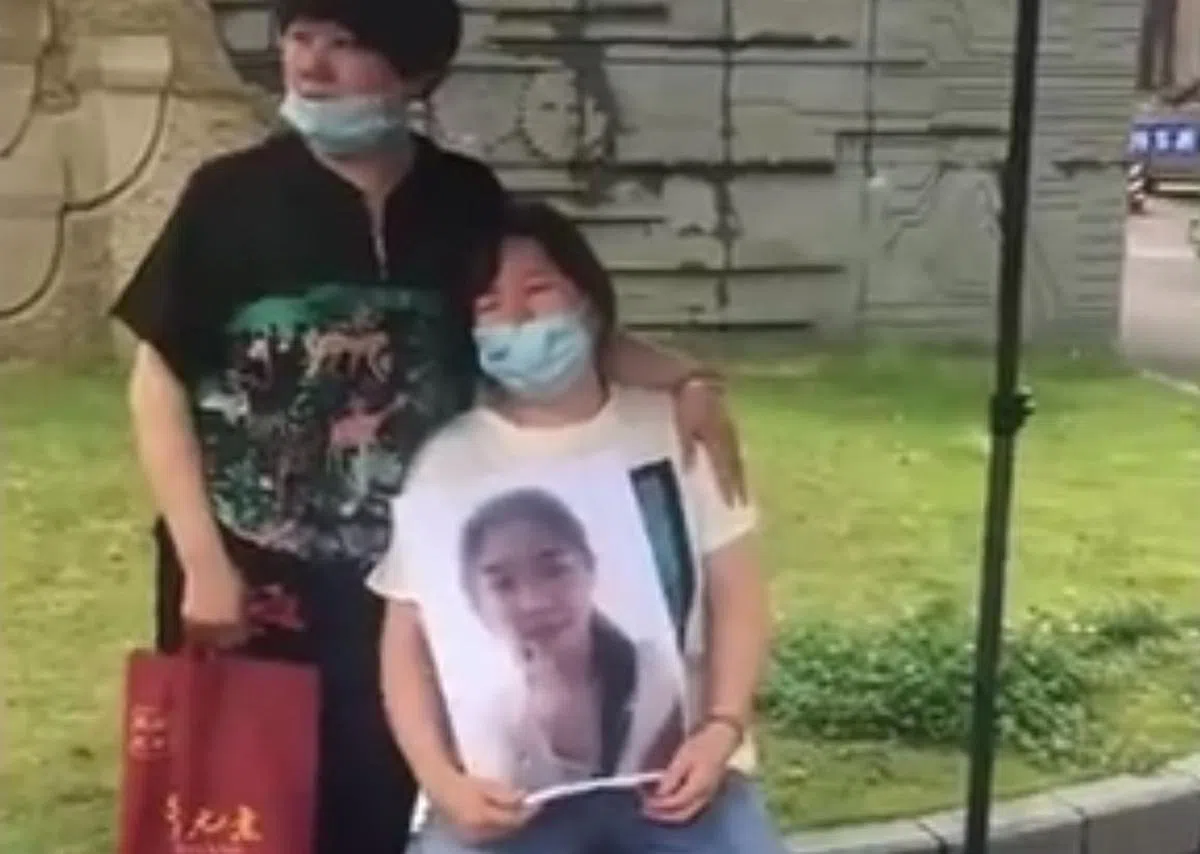 网上流传视频截图显示，在宁波命案中丧命的女生家属，抱着死者遗照在校园外痛哭。（互联网）