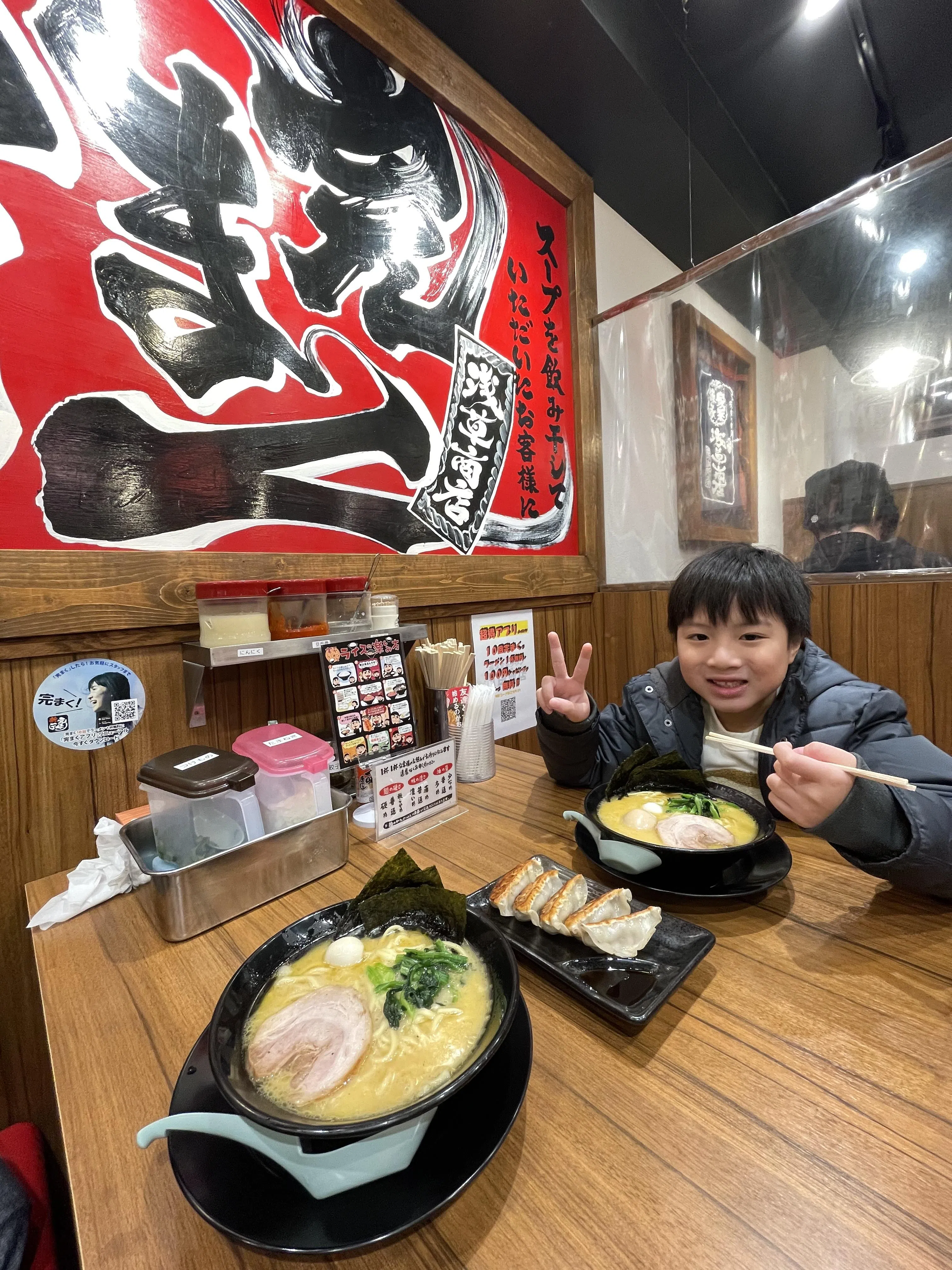 要吃上东京著名拉面店的拉面得排上一小时的队，吴慧珊说儿子相当配合，陪着她排队的同时还与她一起玩游戏。（受访者提供）