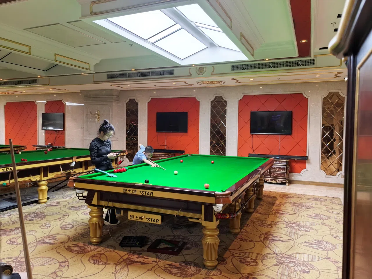 9岁姚东昱（蓝衣）三个月前开始接受斯诺克专业训练，母亲都会陪他一起练球。（周岳翔摄）