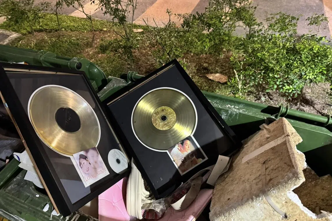 梁伯君把从前制作的张国荣和林忆莲的白金唱片丢掉，象征对曾经觉得珍贵的音乐成绩放手。（取自梁伯君脸书）