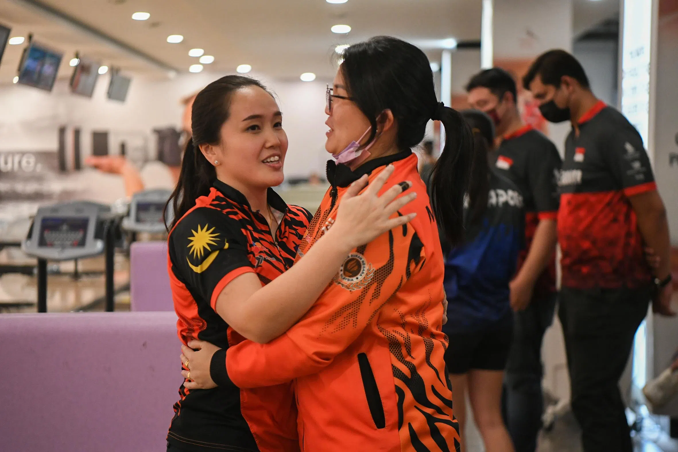 冼丽莹（左）夺冠后，激动拥抱教练庆祝。（海峡时报）