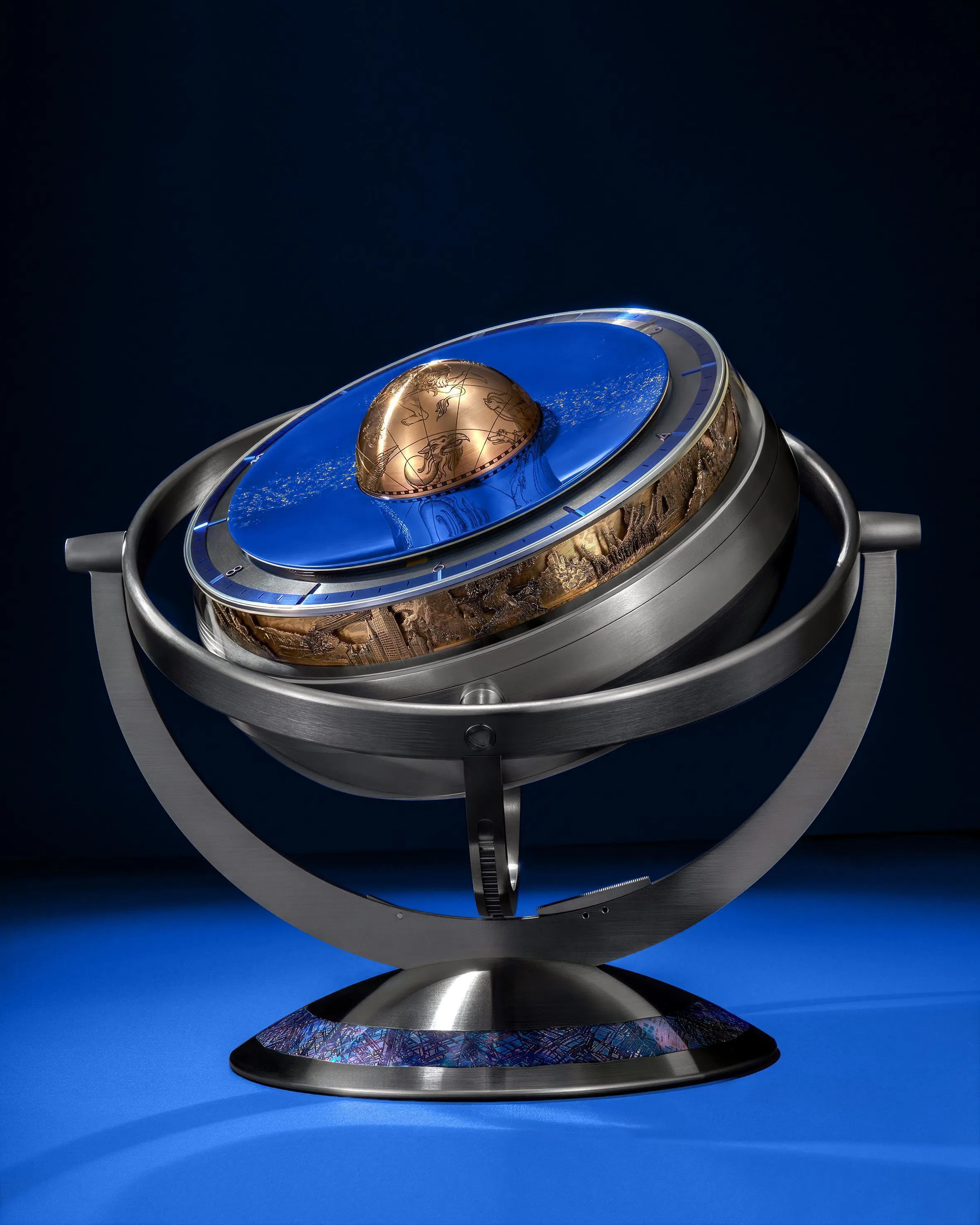 Sympathique座钟固定于蓝色抛光陨石镶嵌钛底座之上，通过倾斜锁定系统实现多角度展示，呼应历史海洋天文钟的可调陈列方式。（De Bethune提供）