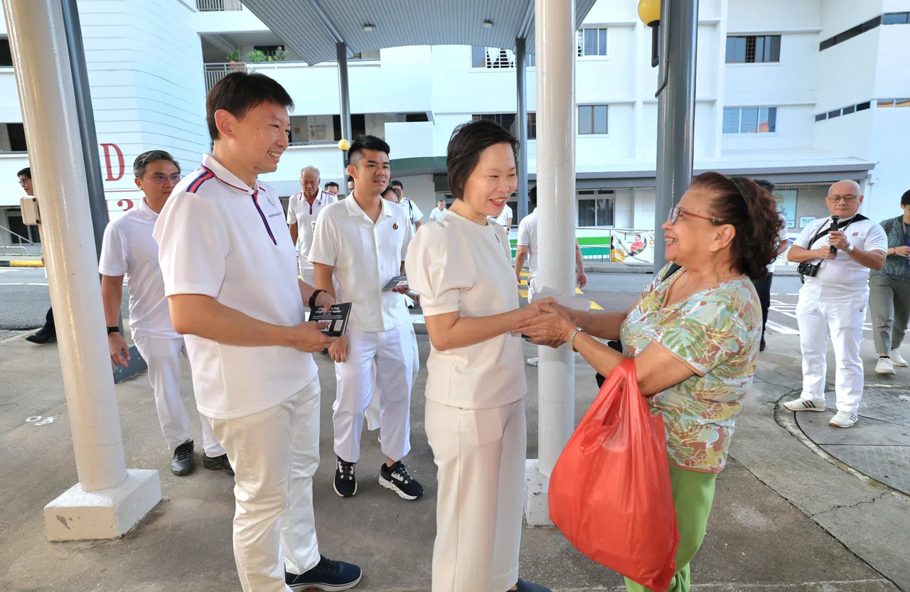 人民行动党玛丽蒙区候选人颜晓芳（中），以及领军碧山—大巴窑集选区的交通部长兼财政部第二部长徐芳达（左二），星期天早上8时一起走访顺福巴刹和熟食中心。（梁麒麟摄）