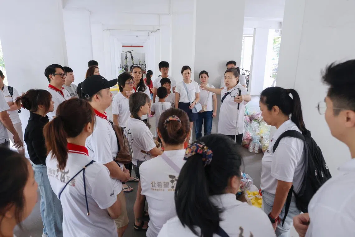 潘迎芬（手持导盲杖）在清理活动开始前，向义工们讲解须注意事项。（游甯稀摄）