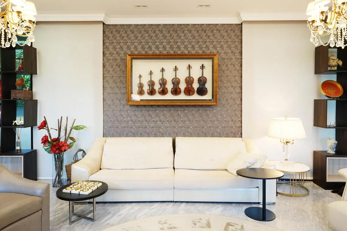 陈秀环将女儿从小到大用过的六把小提琴，框起挂在客厅墙，代表孩子成长的美好回忆。（谢智扬摄）