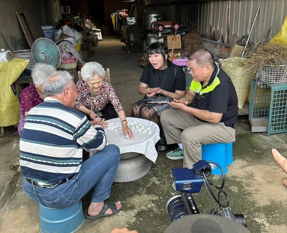 吉那（右二）和父亲标哥（右一）与家人一起搓汤圆话家常。（互联网）