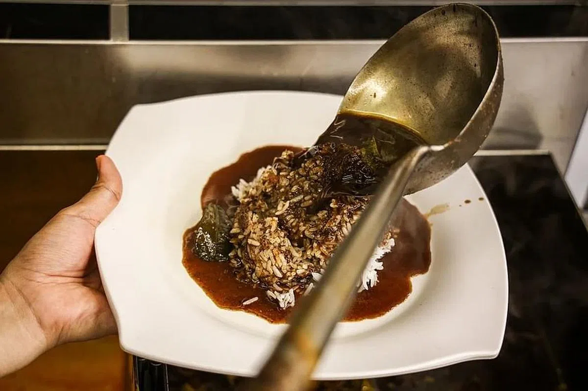 Nasi Rawon的酱汁是以牛肉和牛杂， 加上黑果等材料熬制。 （李健玮摄）