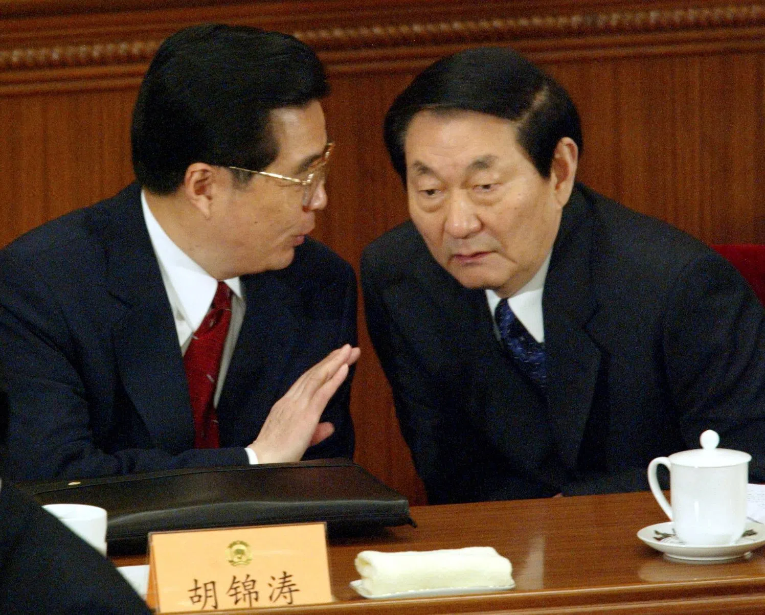 2003年3月14日，时任中国国家副主席胡锦涛（左）在北京举行的全国政协会议闭幕式上，与当时即将卸任的国务院总理朱镕基交谈。（路透社）