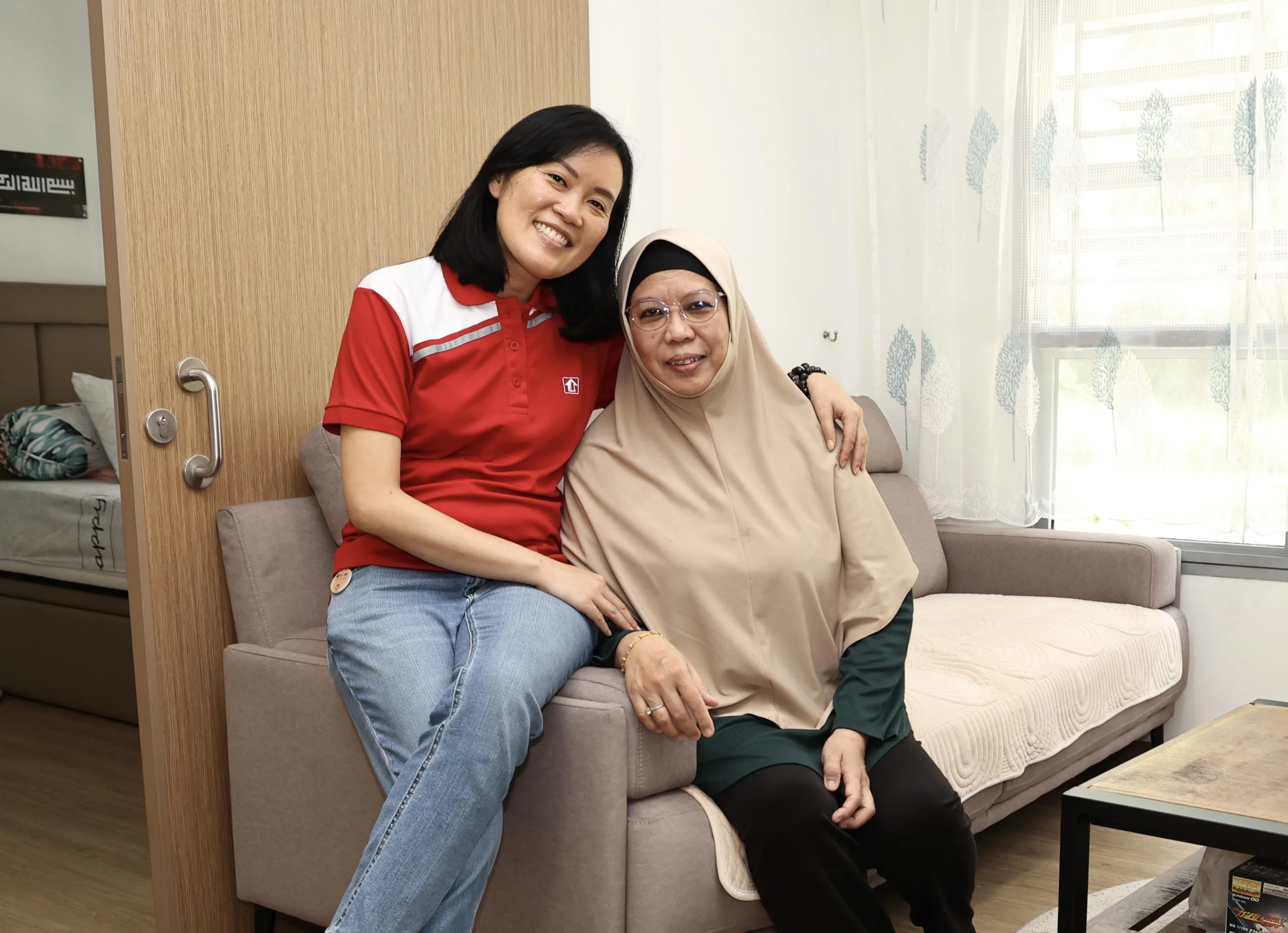 阿莉娅（右）在建屋局房地产业主任经理刘凤莺的协助下实现拥屋梦，去年搬进了榜鹅东的二房式灵活单位。（陈佩敏摄）