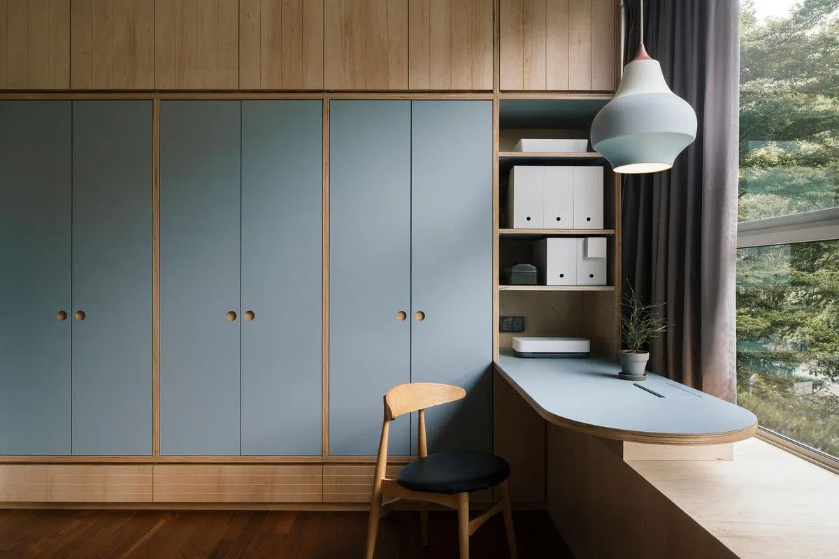 孩子房间的壁橱采用三合板配淡灰蓝色系的橱门，书桌上的吊灯也呼应房内的色系。