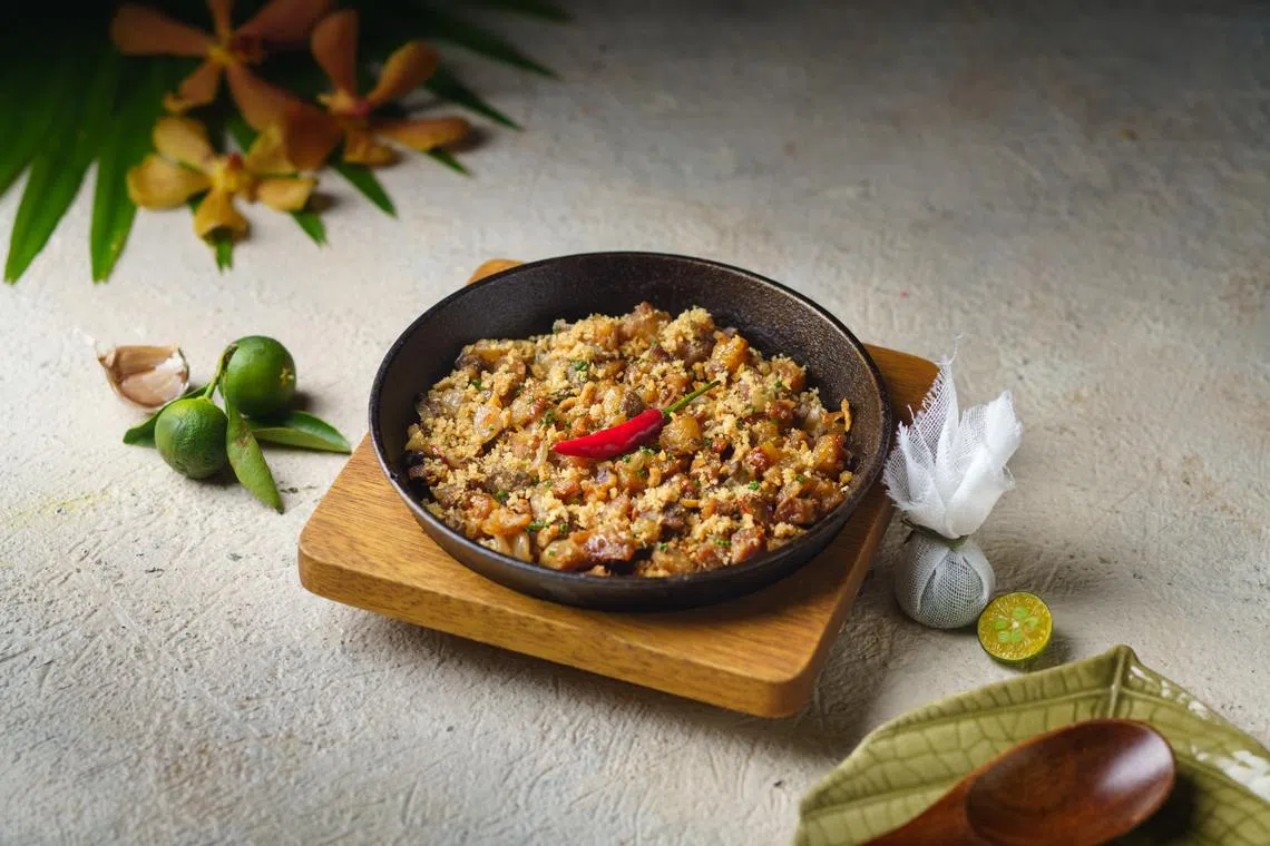招牌菲律宾菜sisig（$22++）以猪肉、猪耳和鸡肝组成，热腾腾上桌很开胃。（餐馆提供）