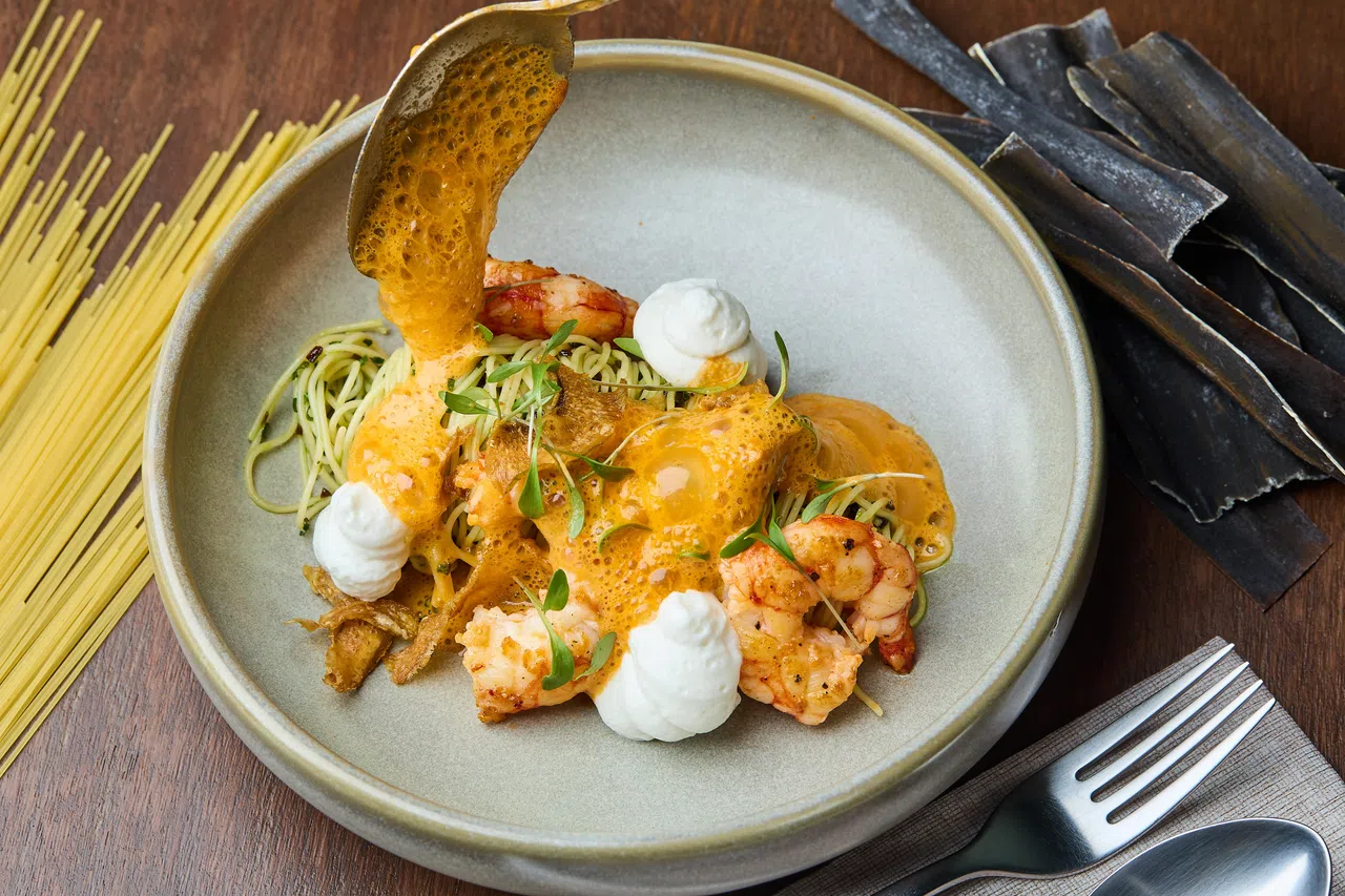 昆布冷天使细面将热虾与冷面搭配，汤底融合泰式椰香与龙虾高汤，再以香茅、辣椒与炸洋蓟提香，冷热交融，层次分明。（餐馆提供）