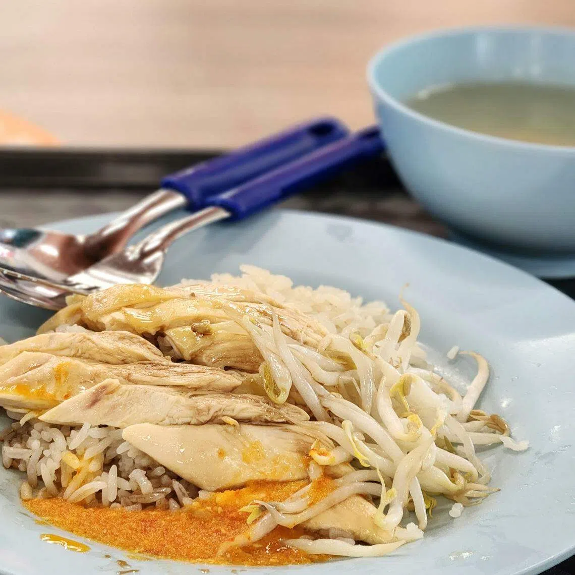 香而不油的鸡饭，配上白斩鸡、豆芽和辣椒，完美一餐。（陈爱薇摄）
