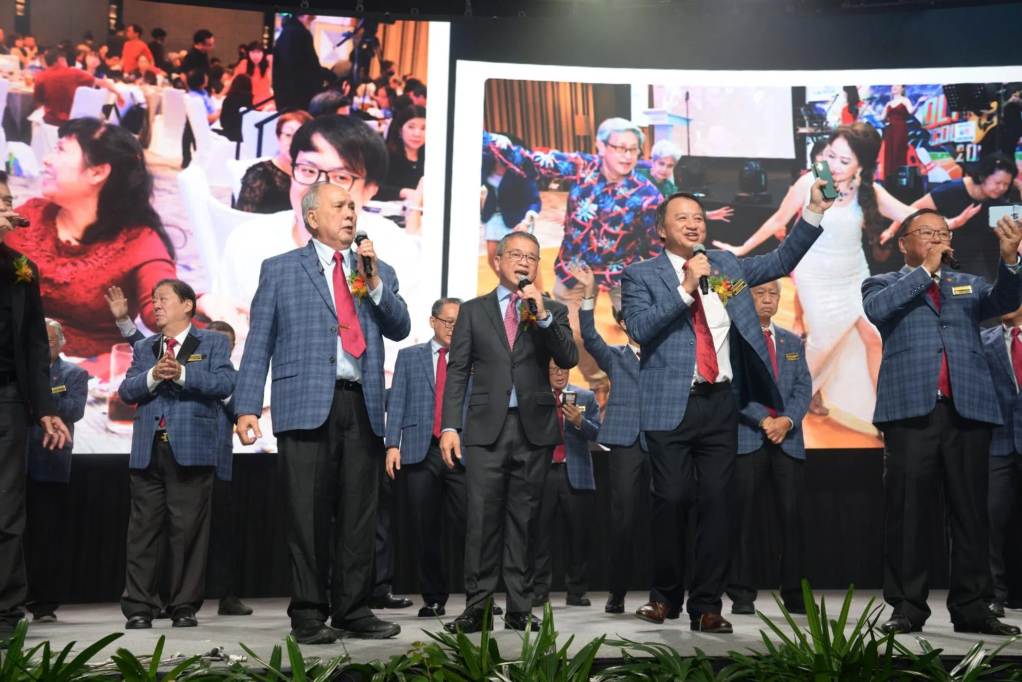 周年庆工委会主席蓝平昌（左起）、唐振辉部长和茶阳（大埔）会馆会长何祥兴在晚宴结尾时，带领大家齐唱《客家世界》。（茶阳（大埔）会馆提供）