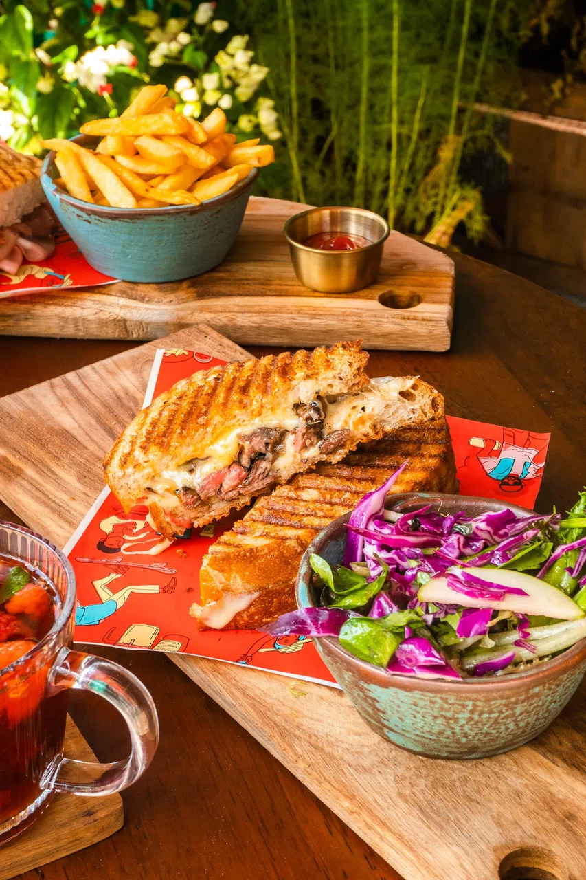 费城芝士牛肉三明治夹着鲜嫩牛肉片、焦糖洋葱、蛋黄酱、切达芝士、马苏里拉芝士等，咬下时咸香入味。（餐馆提供）