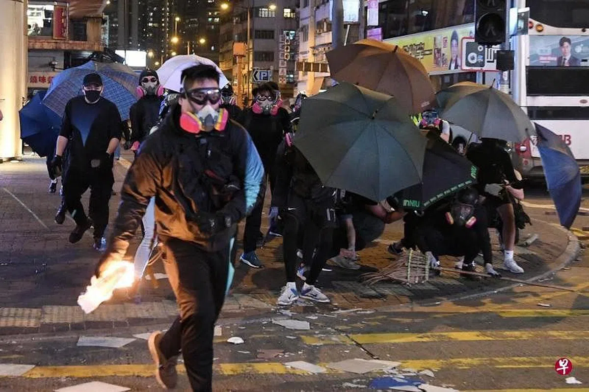 香港反修例抗争者在2019年11月于旺角堵路纵火，并向香港警员投掷燃烧瓶。（香港中通社档案图） 