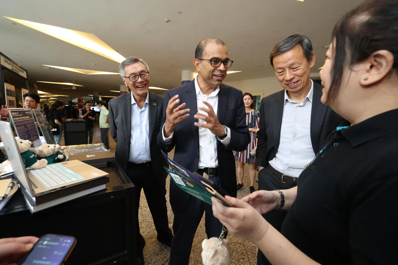 教育部兼永续发展与环境部高级政务部长普杰立医生（左二）在国大校长陈永财教授（左一）和精深技能发展局副局长陈伟明（右二）的陪同下，参观展摊了解各学府的持续教育工作。（郑一鸣摄）