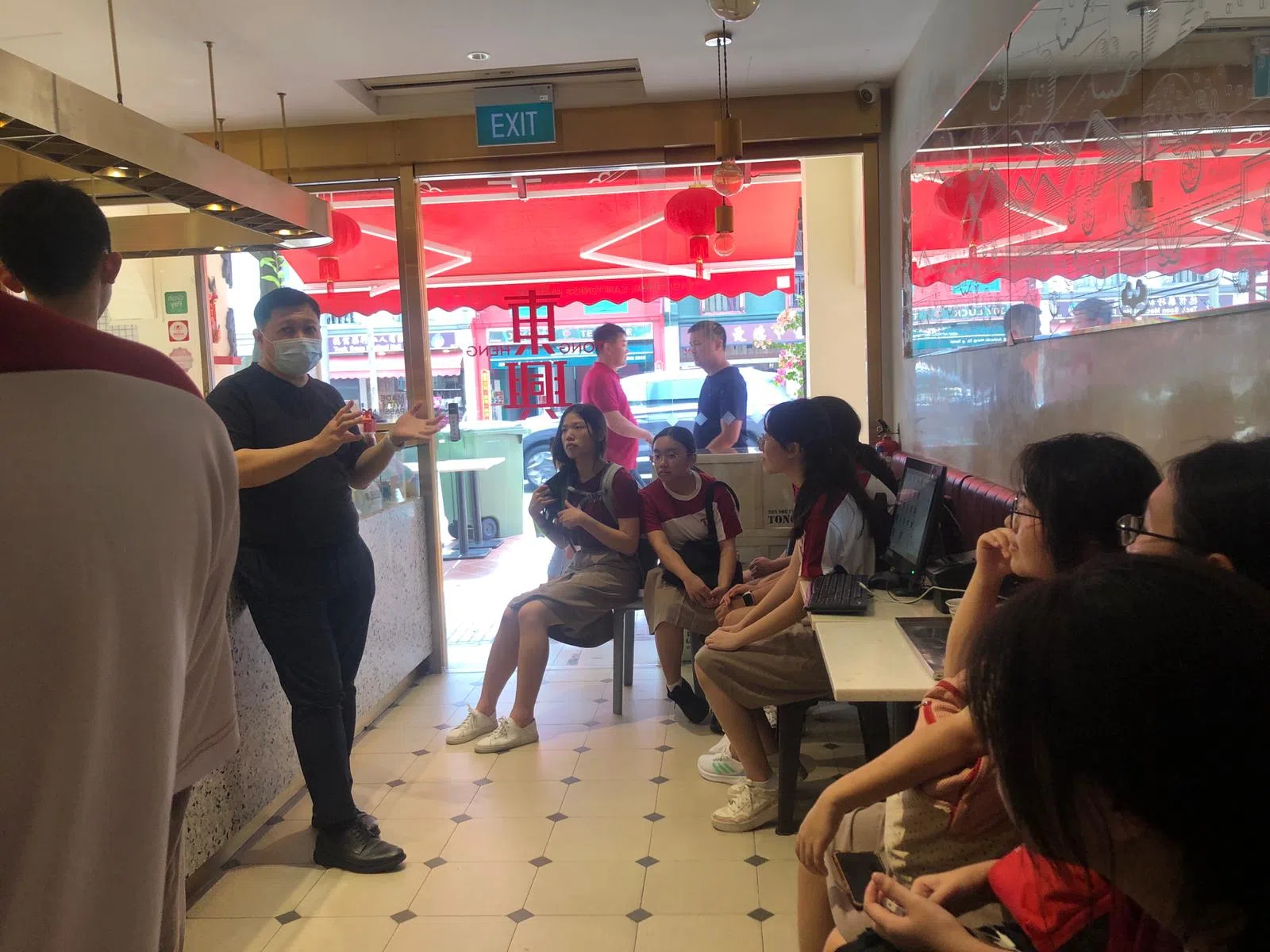 方惠强向学生讲述东兴饼家品牌的历史。（淡滨尼美廉初级学院提供）