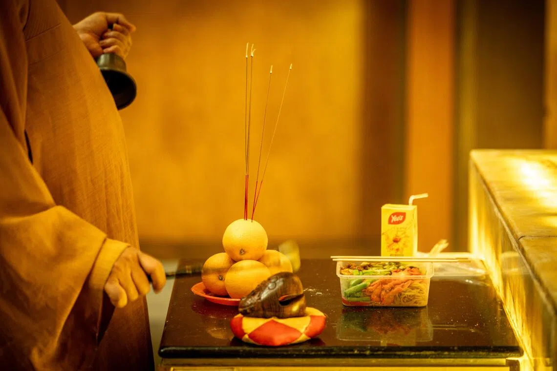 虽然没有丰盛祭品，俞肇斌尽所能为往生者做一场法事，助其除消业障，往生净土。（叶振忠摄）