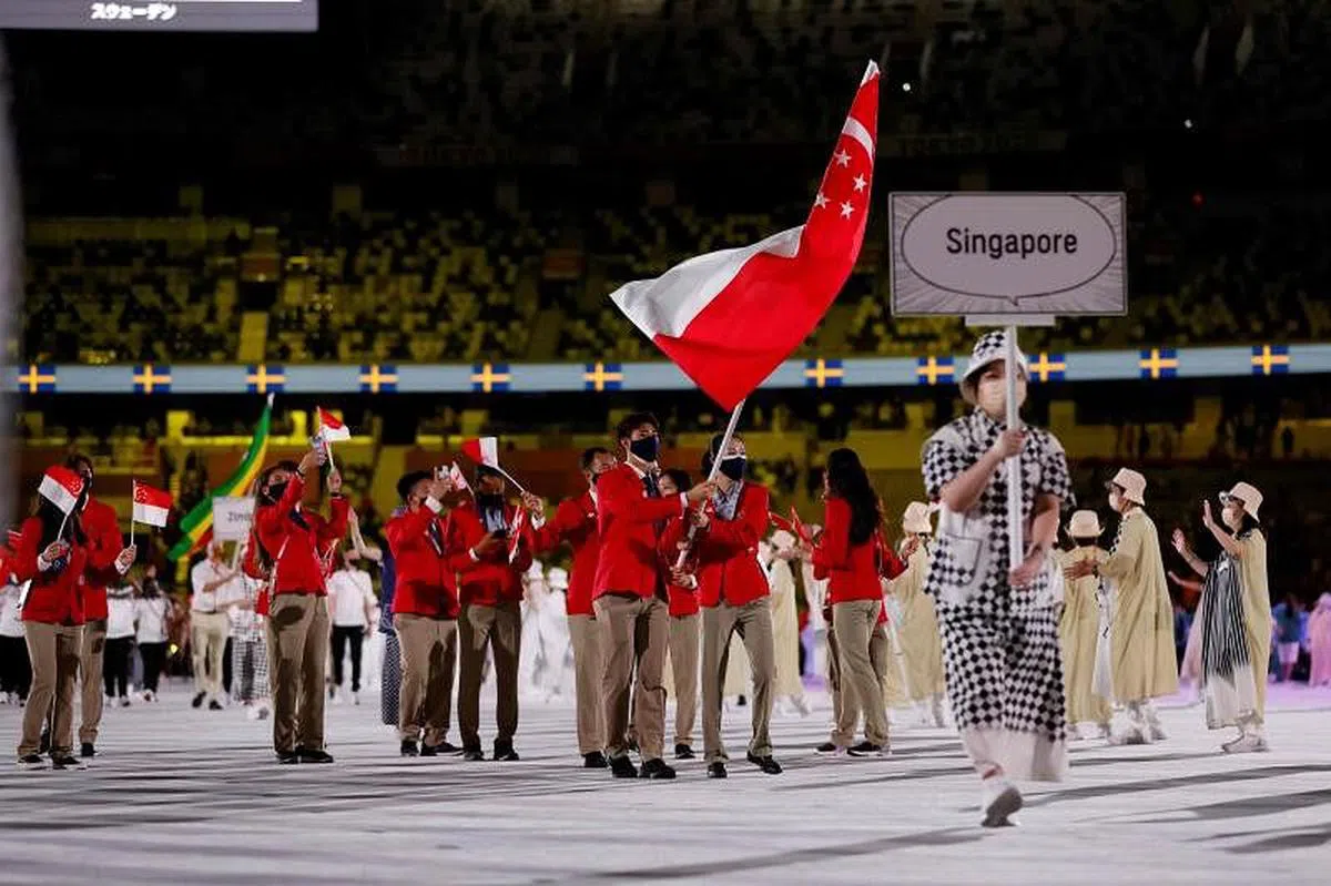 新加坡代表团旗手——羽毛球选手骆建佑（左）和乒乓球选手于梦雨（右）带领新加坡奥运团队进场。（法新社）