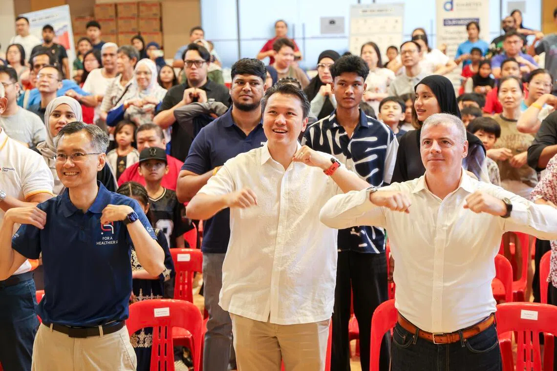 也是财政部兼人力部高级政务次长的西海岸—裕廊西集选区议员的黄伟中（前排中）和糖尿病协会主席马荣茂医生（前排左一）等，在达曼裕廊民众俱乐部和公众一起做健身操，鼓励通过健康生活方式预防糖尿病。（陈斌勤摄）