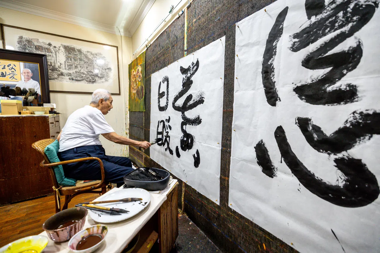 林子平看到毛笔就开心，在住家二楼画室写字作画。（叶振忠摄）