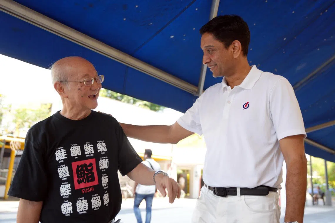 访问过程中，有居民主动上前向迪内希（右）问好。（谢智扬摄）