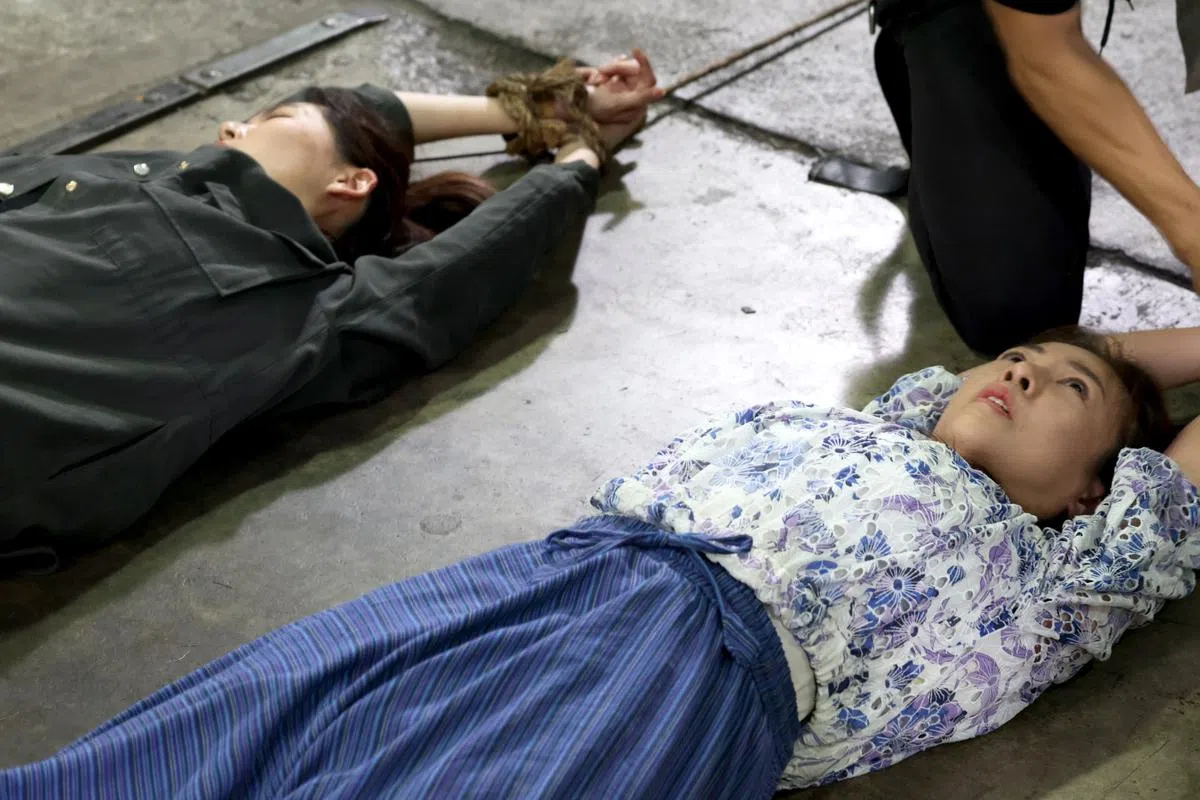 刘子绚（右）和黄思恬被绑着，全身被绳子拖拉着。（龙国雄摄）