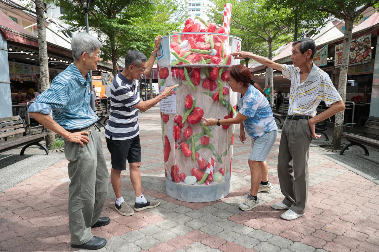 在人协百盛艺术号召下，四名艺术工作者刘炜康（左起）、 曾荣松、许婉荷及卢国华带领武吉巴督东居民完成巨型美食装置艺术。（李冠卫摄）