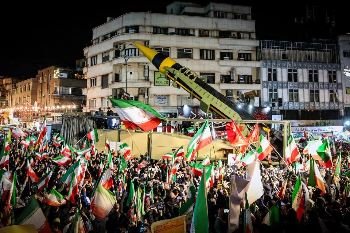 伊朗民众周二聚集在德黑兰的革命广场和瓦纳克广场，参加反对美国和以色列的示威活动。他们挥舞伊朗国旗，并高喊口号，伊朗武装部队还在现场展示弹道导弹。（路透社）