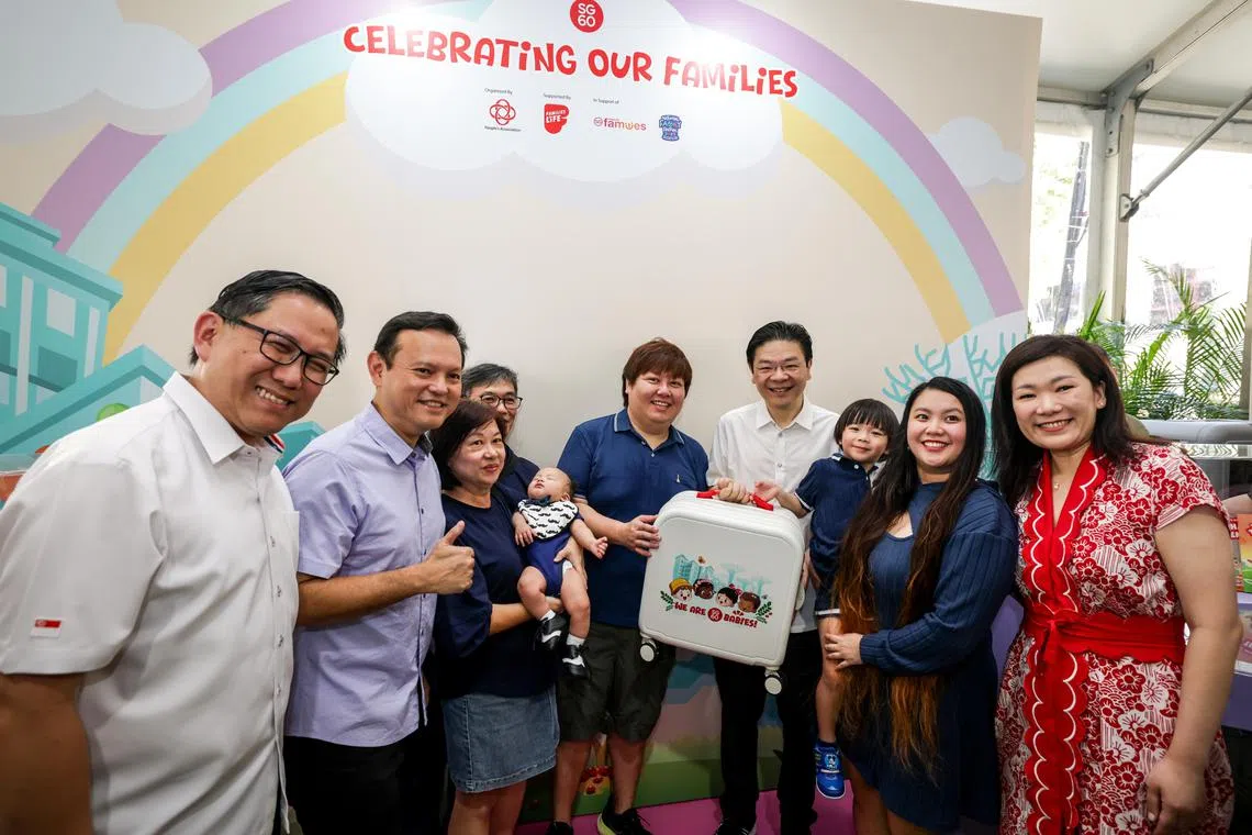 四名马西岭—油池集选区议员——黄循财总理（右四）、人力部兼国防部高级政务部长扎吉哈（左二）、西北区市长任梓铭（左一）及苏慧敏（右一）星期六向居民刘秀凤（右二）一家，送上SG60婴儿礼包。刘秀凤第二胎的预产期原本是去年底，但二儿子陈烨玚（左三，抱在怀中）今年1月3日出生，恰好成了一名SG60宝宝。（叶振忠摄）