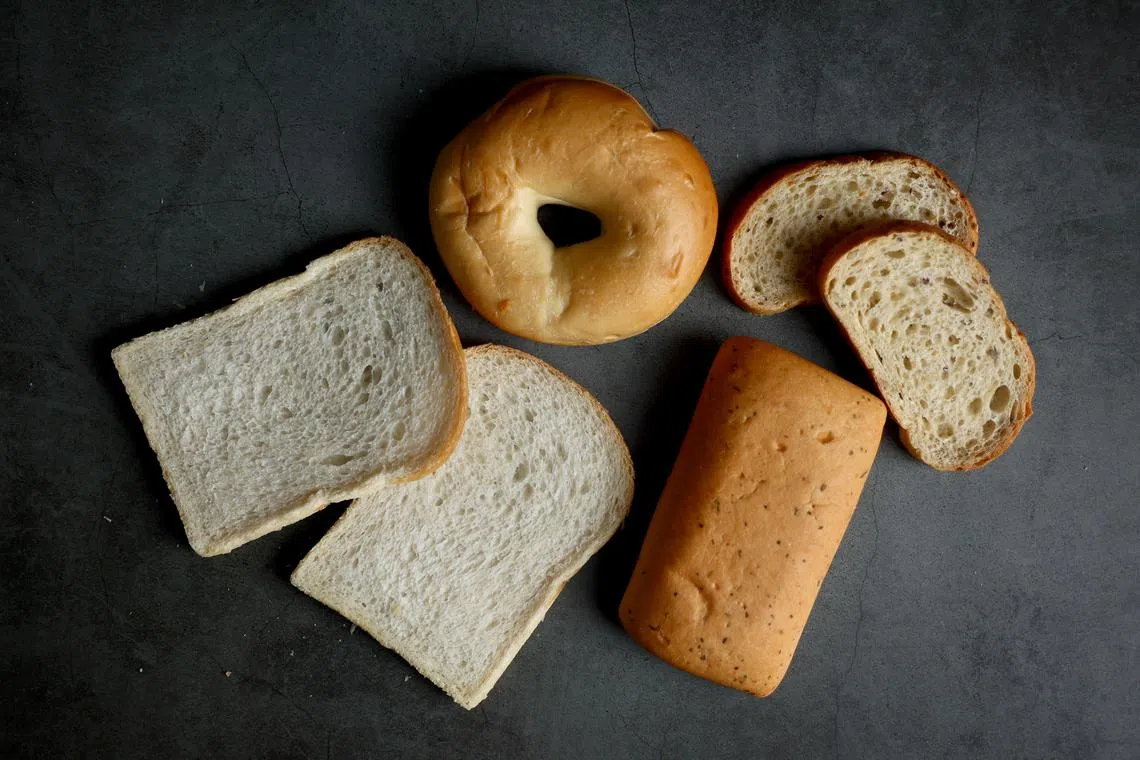 超市售卖的酸种面包，包括酸种白面包（左起，顺时钟）、贝果、多谷乡村面包和意大利三文治（panini）面包。（龙国雄摄）