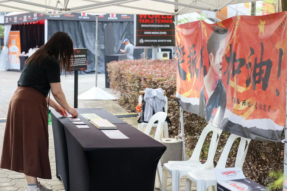 一名樊振东球迷正在整理手幅。（卓祾祎摄）