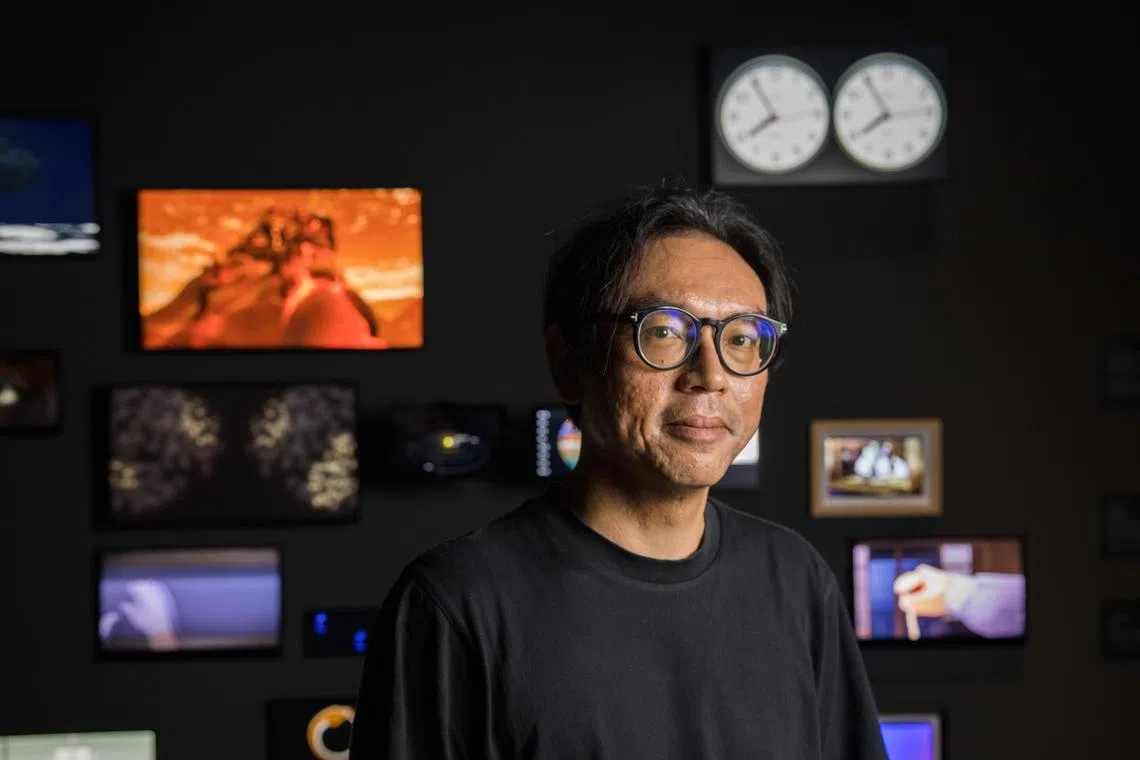 艺术家何子彦在录像装置《“T”条的“Time”（时间）》前留影。（新加坡美术馆提供）