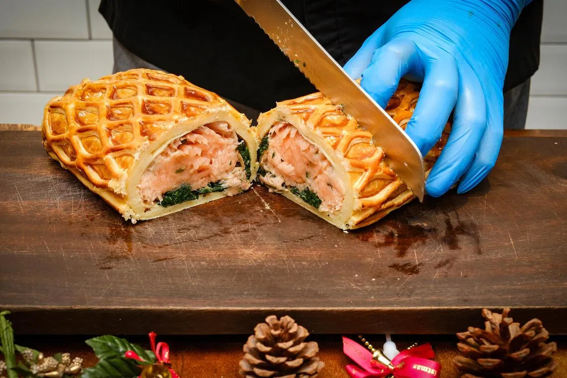 选择锋利的锯齿刀慢慢锯切，可避免酥皮被压扁变形，切出好看的利落切面。（曾坤顺摄）