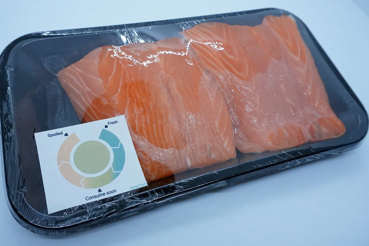 纸质的智能食品标签能根据食品散发的生物胺浓度变色；介于绿色和橙色之前，就提醒消费者要尽快食用，而标签转为橙色即表示食品已变坏。（图/城大提供）