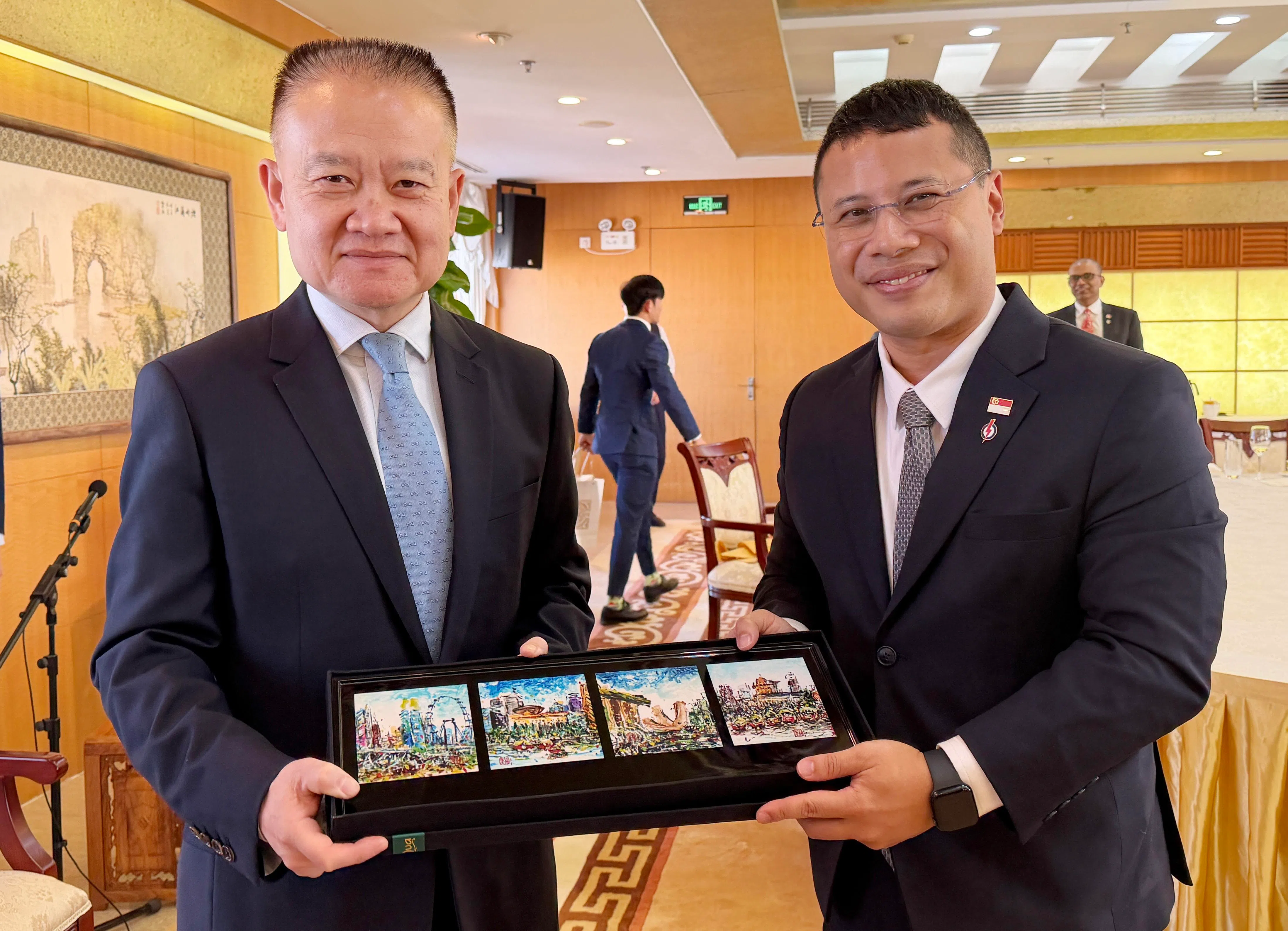 率领人民行动党代表团访问中国的行动党主席李智陞（右），向中共中央对外联络部部长刘海星赠送纪念品。（人民行动党提供）