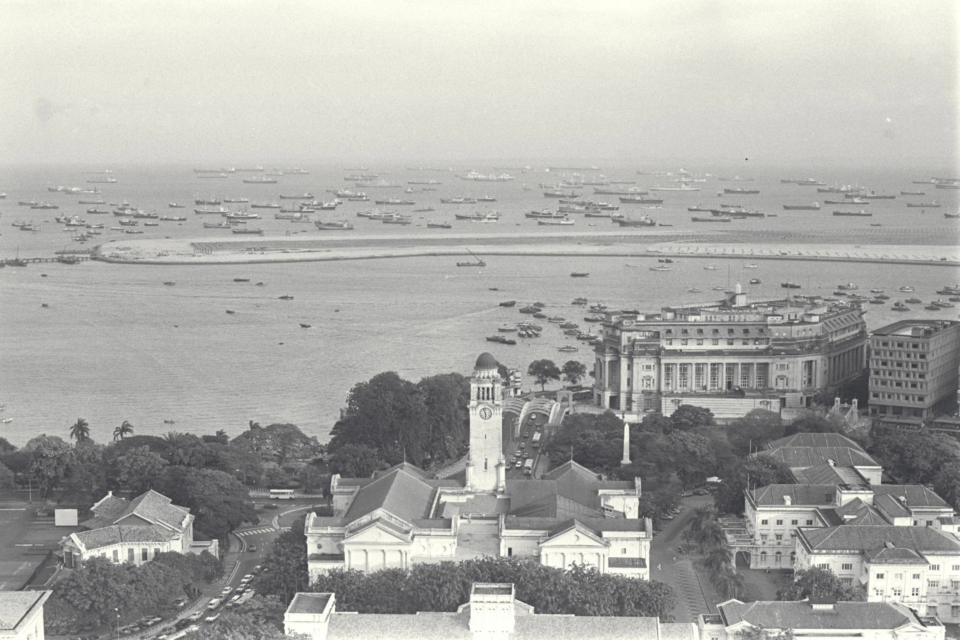 新加坡是繁忙转口贸易港，远洋货船停在外海，再由大䑩船把货物运到码头。（档案照）