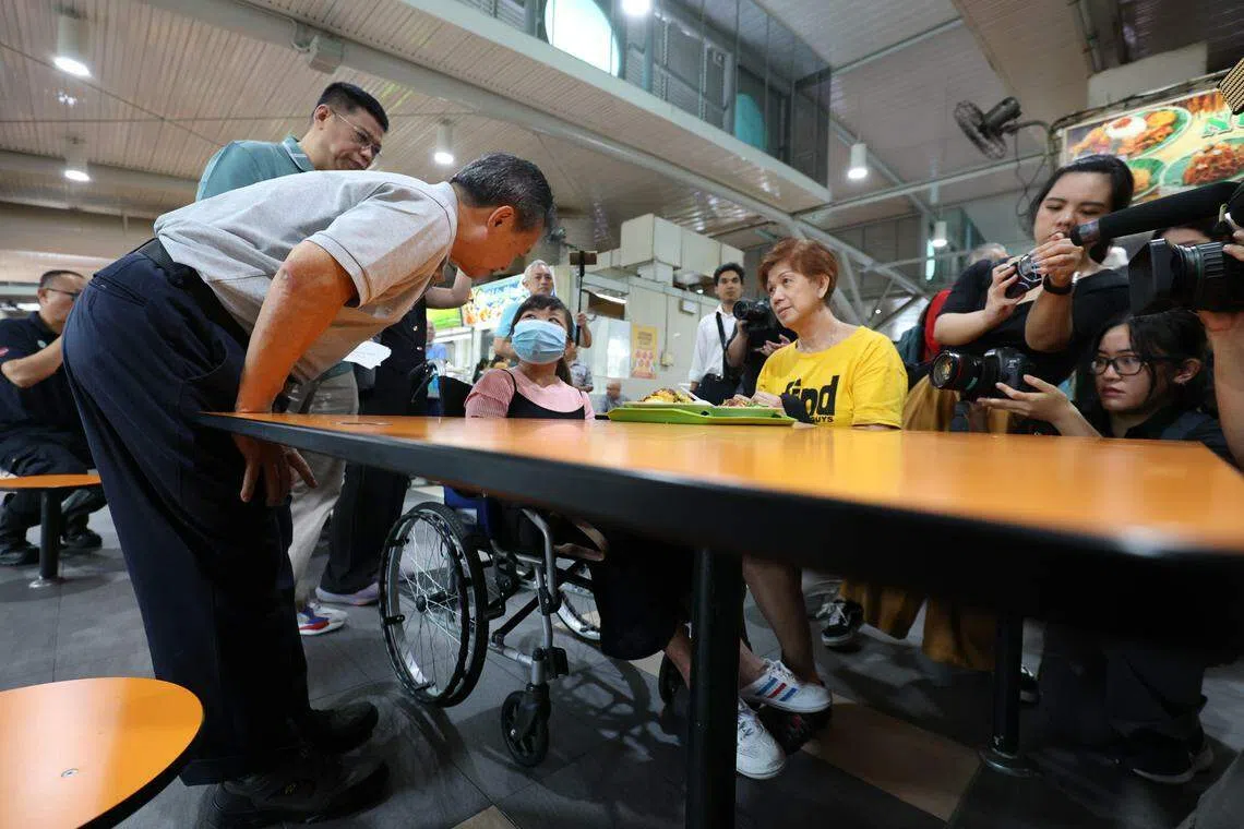 8月23日，总统候选人陈钦亮（灰色衣服者）到ABC砖厂熟食中心与公众互动，期间与一名轮椅使用者交谈，聆听对方心声。（何家俊摄）