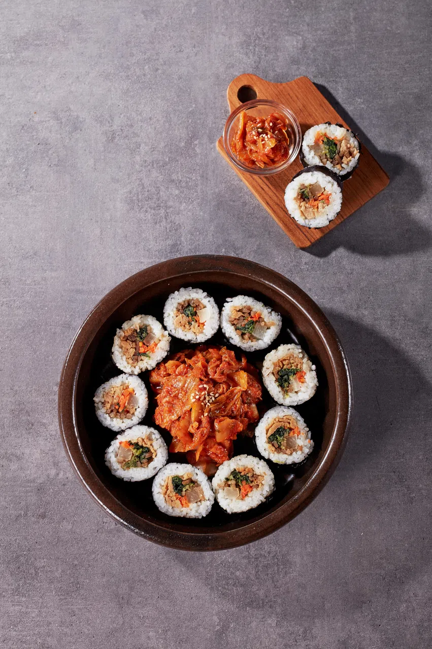 韩式饭卷有多款口味，搭配泡菜上桌。（餐馆提供）