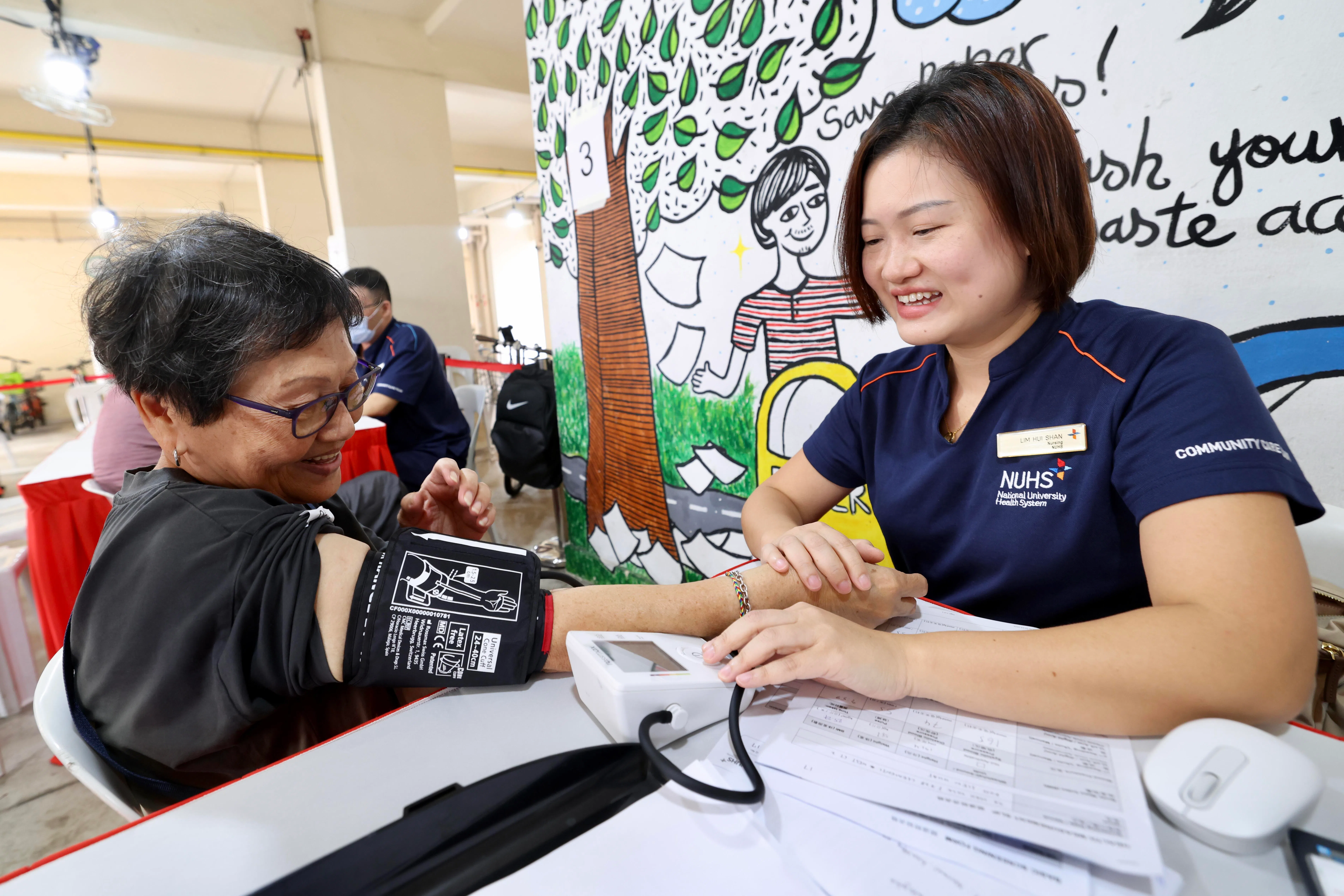 国大医学组织社区关怀组的临床护士林慧珊（右）星期六在“健康同行”嘉年华上，为亚逸拉惹居民许秀月测量血压。（陈斌勤摄）