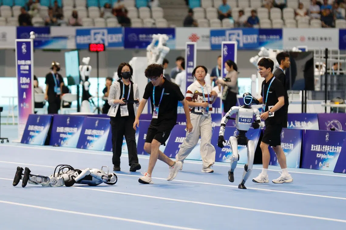 人形机器人星期六（8月16日）在田径项目100米预赛中摔倒。（中新社）