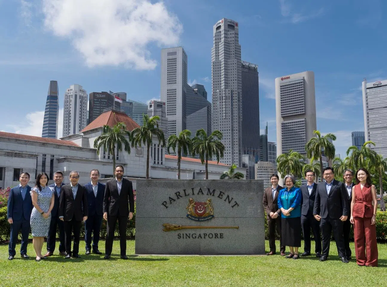 毕丹星（左六）星期五傍晚在社交媒体贴出一张12名工人党议员在国会大厦前一字排开的照片，只写上“为国效劳”的2025年大选口号，没有对这几天的辩论发表任何看法。（取自毕丹星脸书）