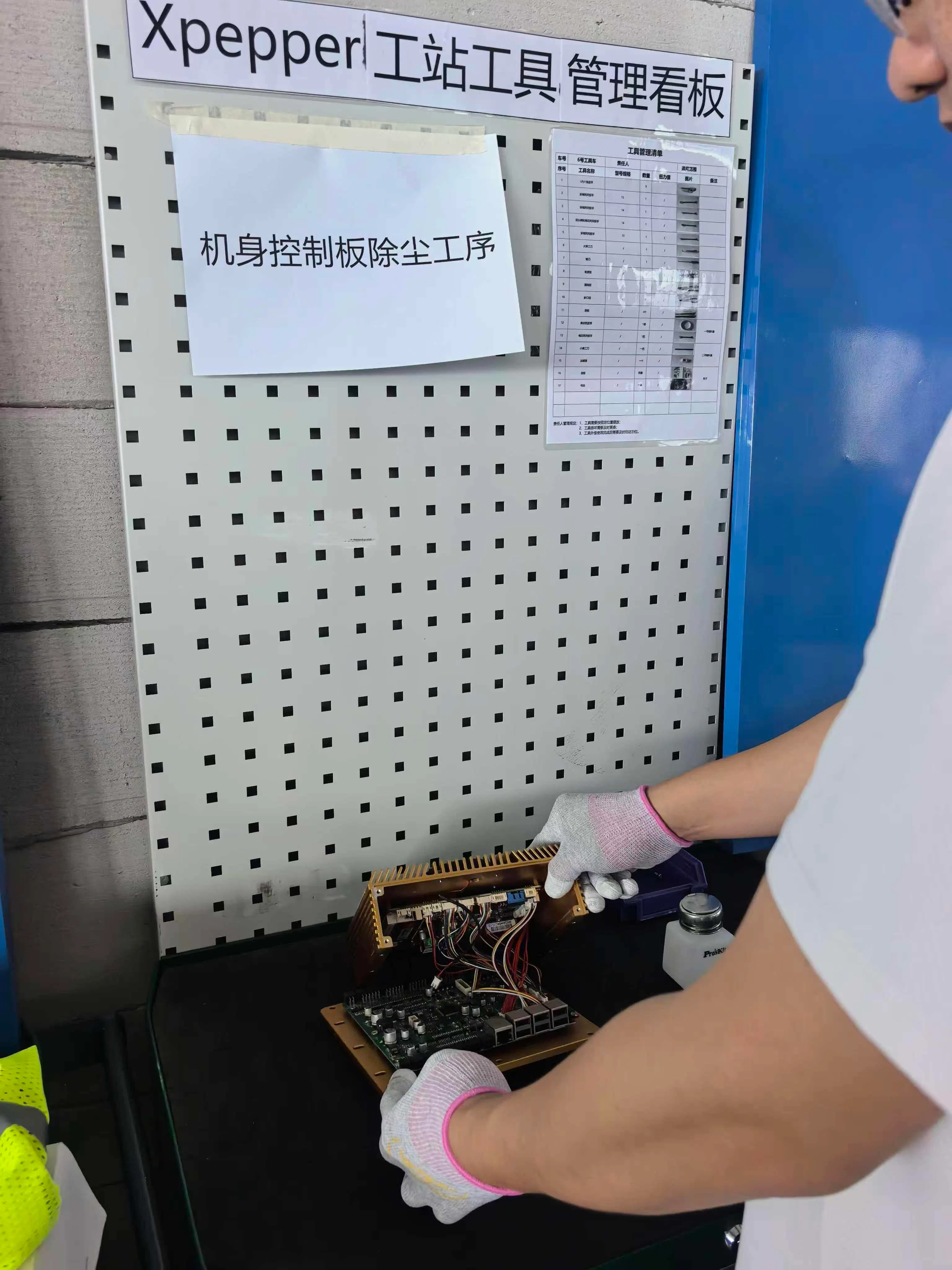 数据采集员头戴摄像头完成机身控制板除尘，记录下双手操作过程，让机器人从真实作业中“学习”这一工序。（受访者提供）