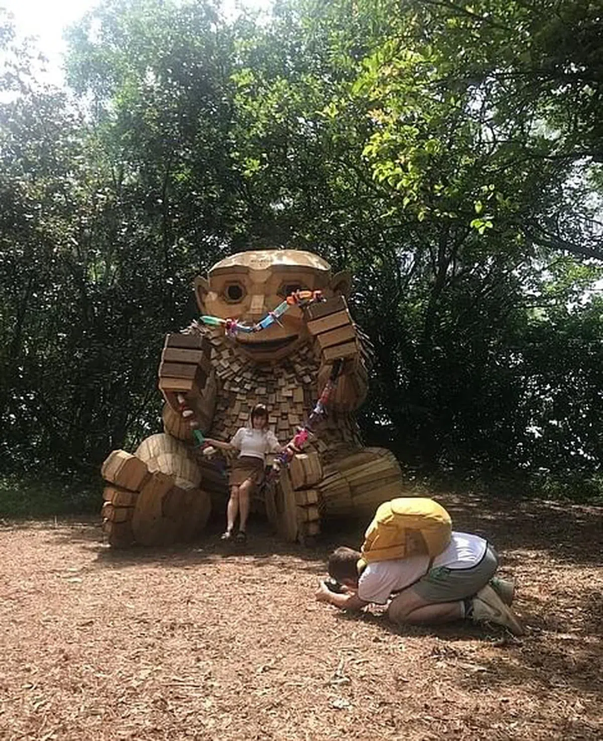 艺术家丹博（右）替访客与自己的作品《礁石酋长》拍照。（黄向京摄）