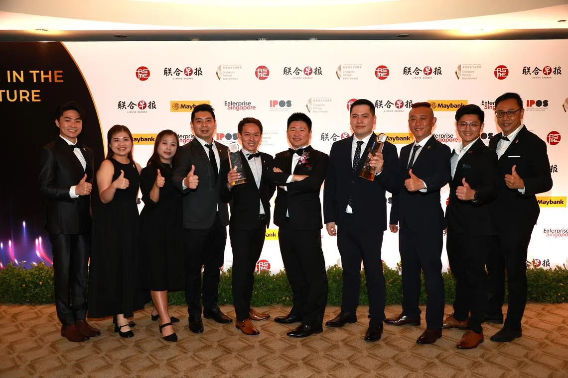 成名品牌总冠军店小二创办人叶权坤（左六）与团队合照。（邝启聪摄）